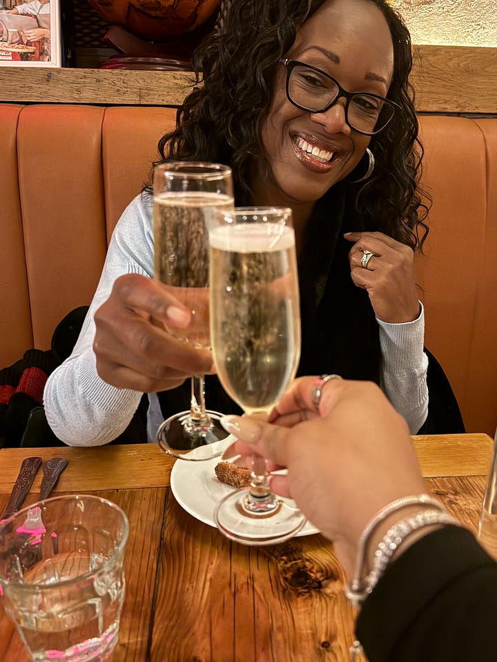 Author, Bernette, and daughter toasting wine and a picture of the appetizer with seven dishes.