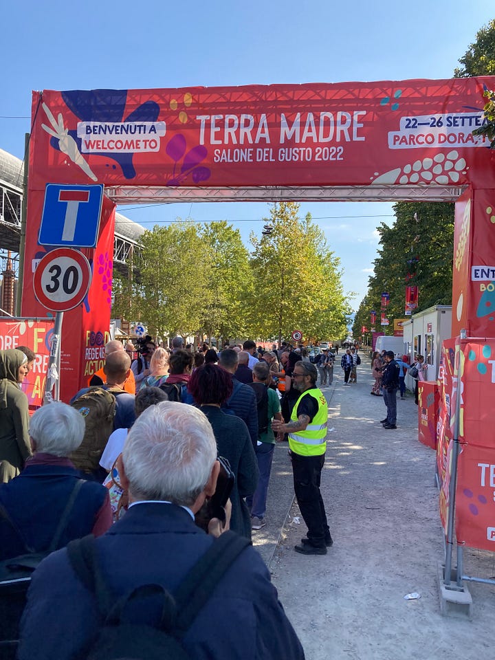 Four colourful images of people queuing to enter the Terra Madre event in Turin in 2022, and one of a large blue snail which is the logo of Slow Food.