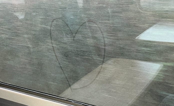 A heart drawn in the condensation on a rainy window