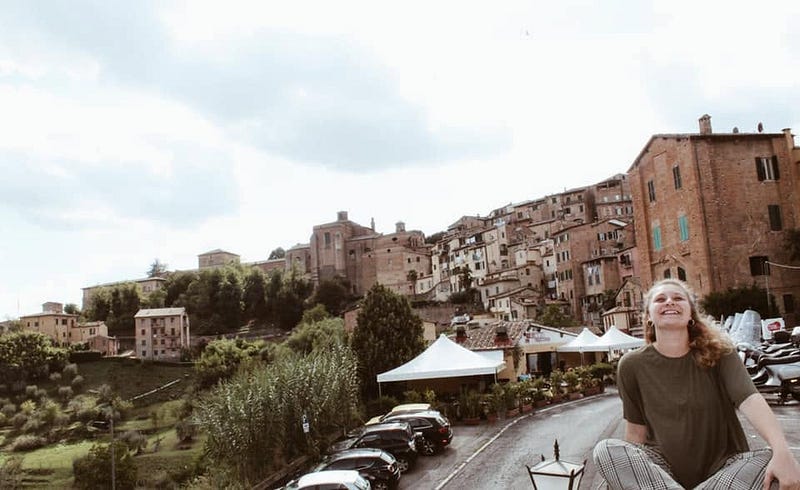 Kailee smiling in front of a hilltop town in Italy